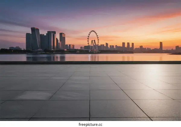 Beautiful cityscape at sunset with modern buildings and a Ferris wheel