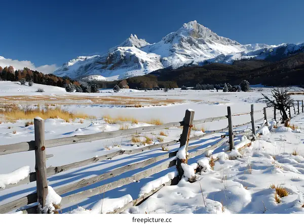 Snowy mountain landscape with wooden fence