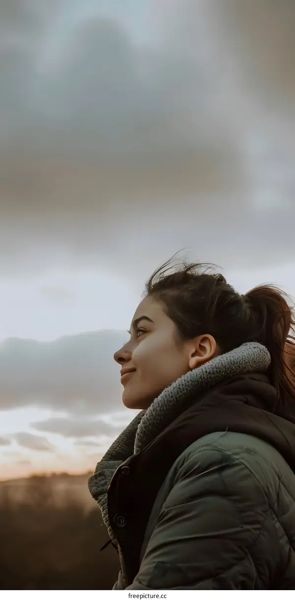 Woman in a Jacket Looking Up at the Sky