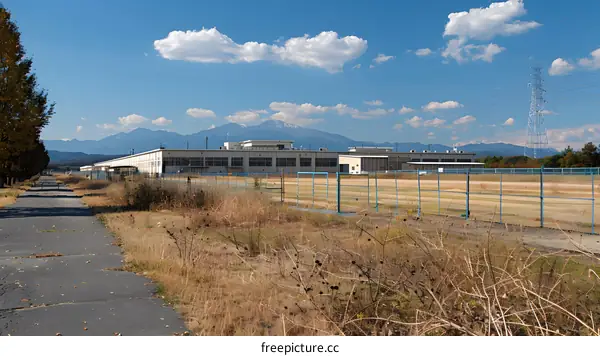 An abandoned factory building with a mountain in the distance