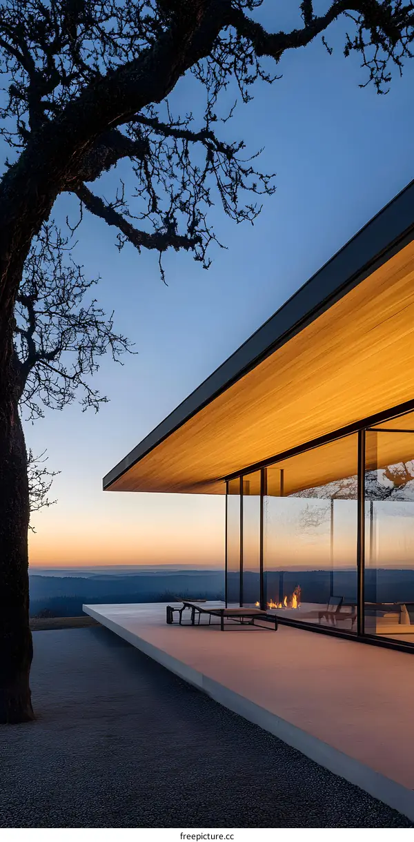 Modern House with Large Windows and a Patio Overlooking a Sunset