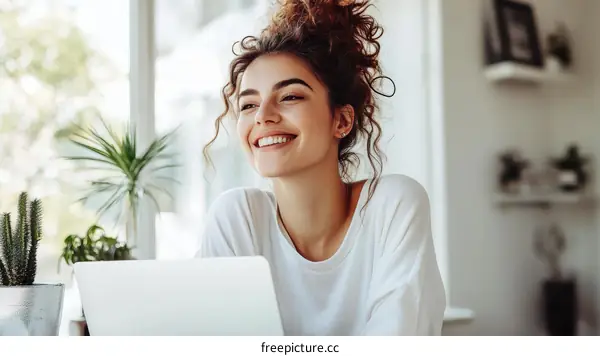 Smiling Woman Working on Laptop by the Window