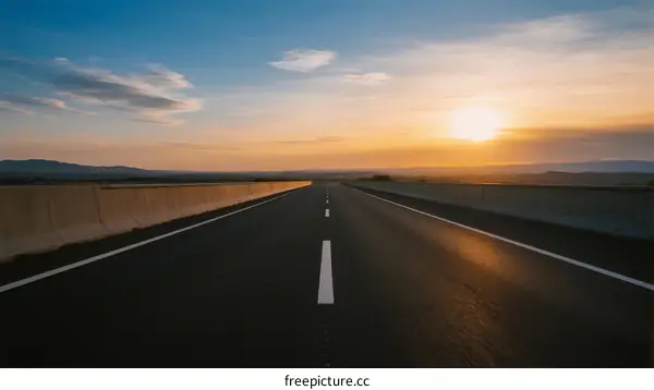 Sunset over an empty highway stretching into the distance