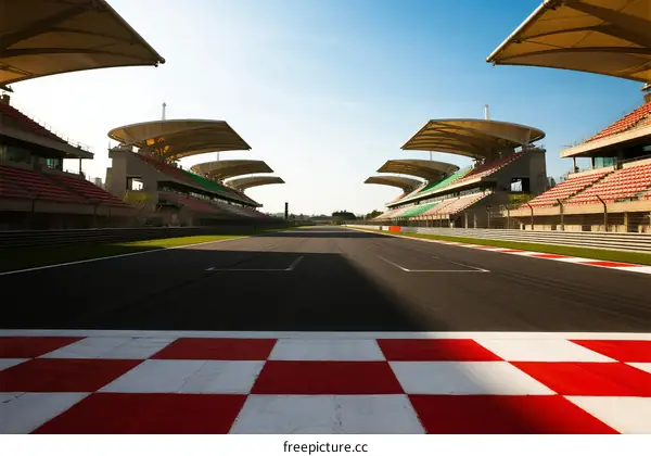 Empty race track with grandstands under clear sky