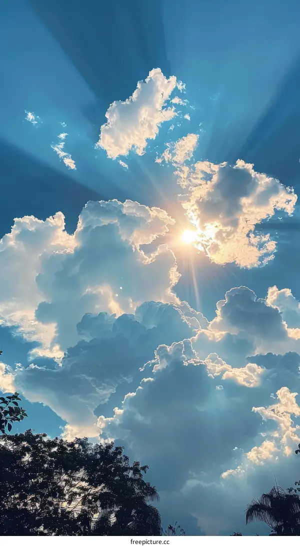 Blue sky and white clouds with sun rays shining through the clouds