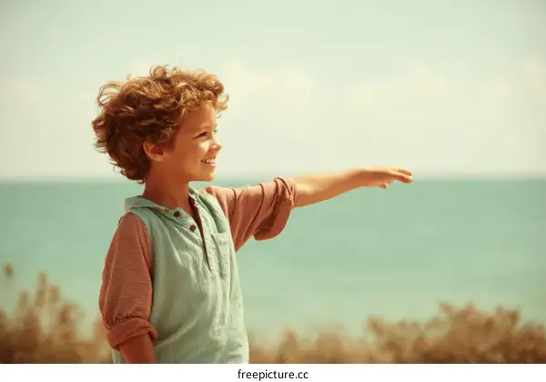 Happy boy reaching out to the ocean