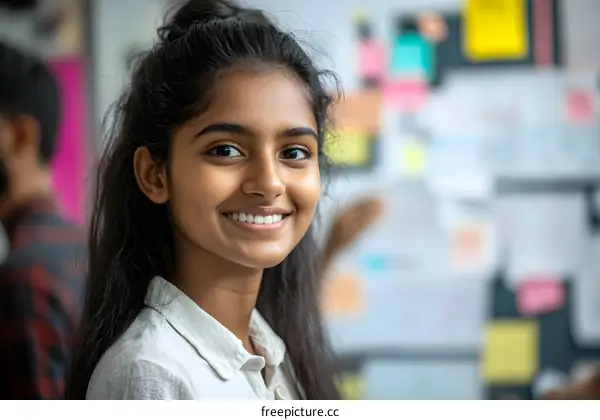 Smiling Young Indian Woman in White Shirt Looking at Camera in an Office