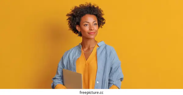 Confident Woman Holding Laptop Against Solid Background