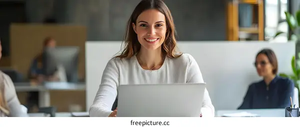 Smiling Woman Working on Laptop in Office