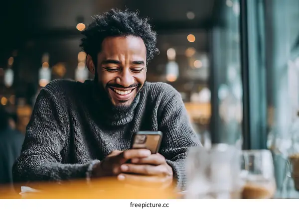 African Man Using Smartphone in Cafe