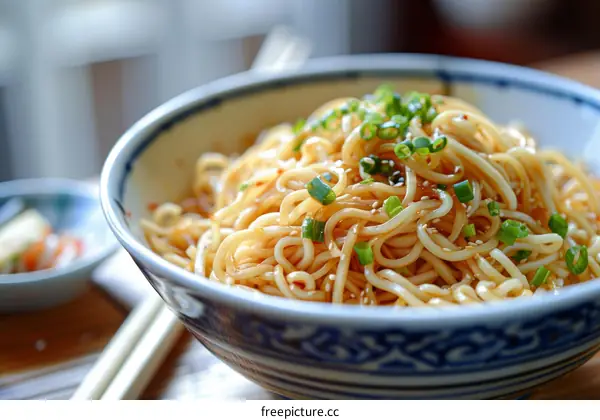 A bowl of noodles with chopsticks on the side