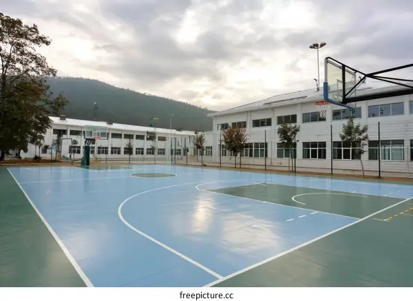Outdoor Basketball Court by Modern School Building