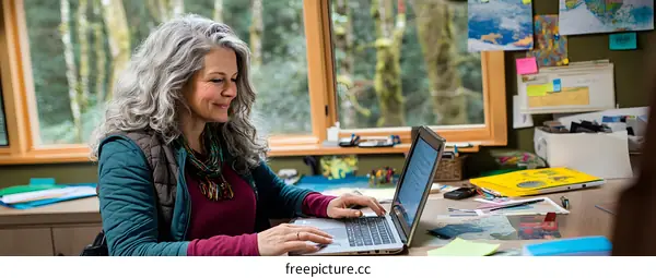 Senior Woman Working On Laptop in Home Office