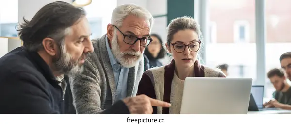 Three People Working Together on a Laptop in an Office Setting