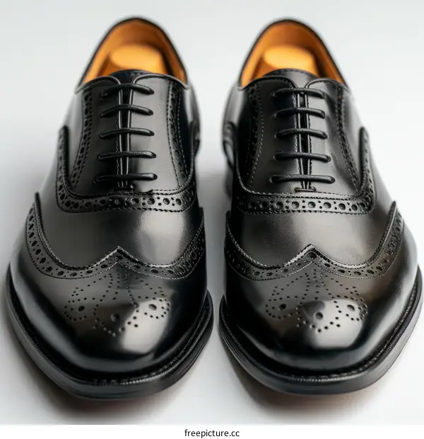 Black leather shoes with brogue details and black laces