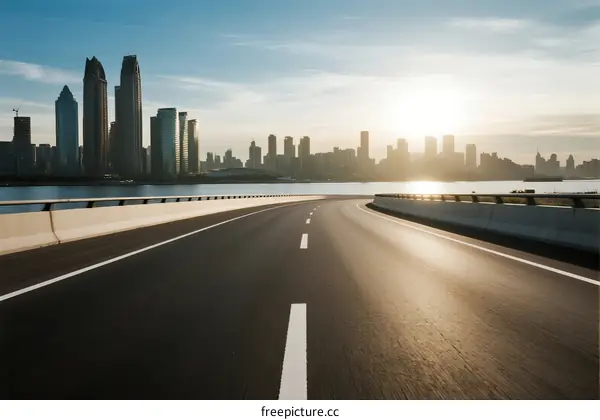 Sunset view of an empty highway leading to a modern city skyline