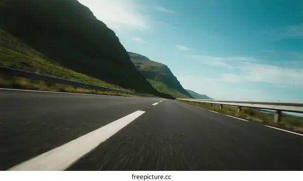 Driving on a scenic road with mountain views under a clear sky