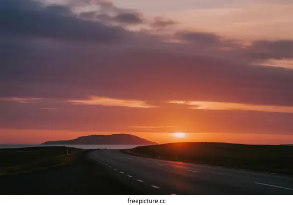 Beautiful sunset over a long empty road with distant landforms