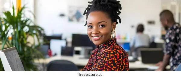 Smiling African American Woman Working At A Desk In An Office