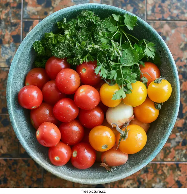A bowl of red and yellow tomatoes with parsley and shallots
