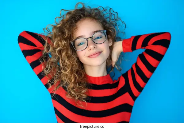 Teenage Girl with Curly Hair in a Striped Sweater