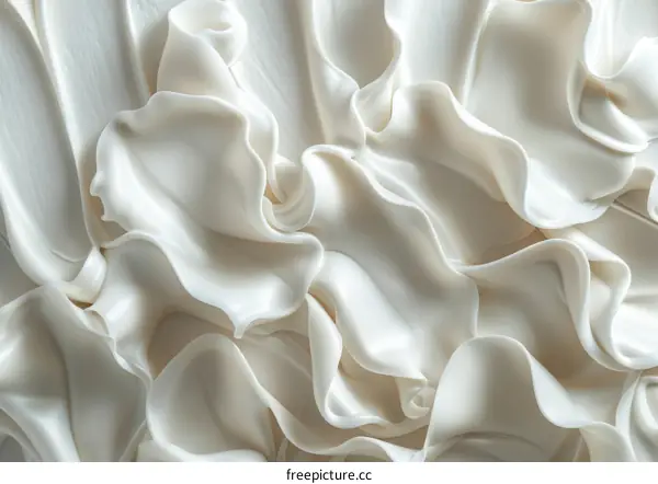 Close-up image of white cream with smooth wavy surface texture