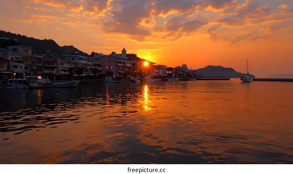 Sunset Over Harbor with Boats and Buildings