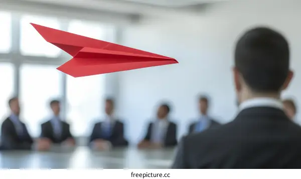 Red paper plane flying in a business meeting