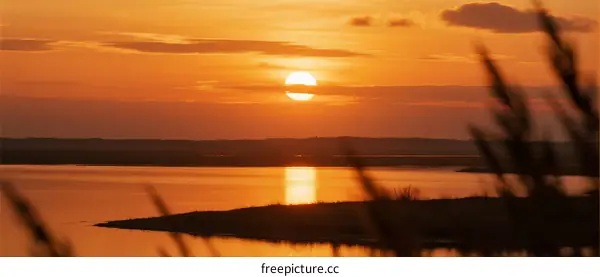 Beautiful sunset over a calm body of water with orange sky