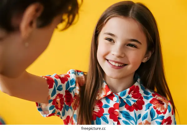 Young girl with long hair smiling and interacting with someone
