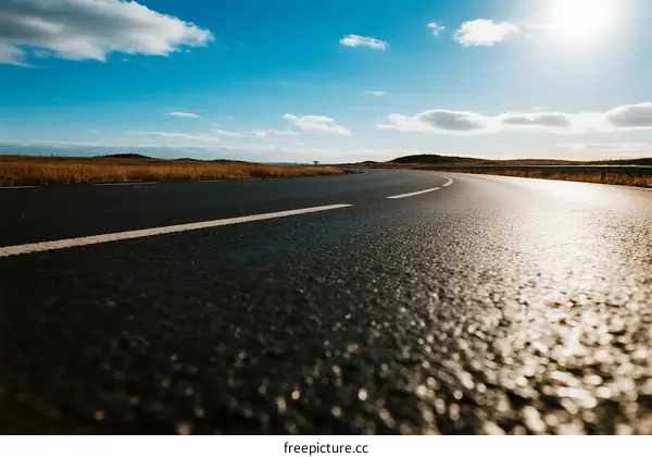 Sunny road with clear blue sky and open landscape