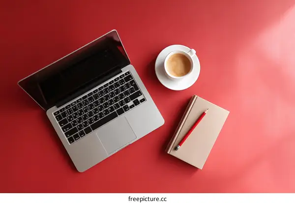 Red Desk Workspace with Laptop Coffee and Notebook