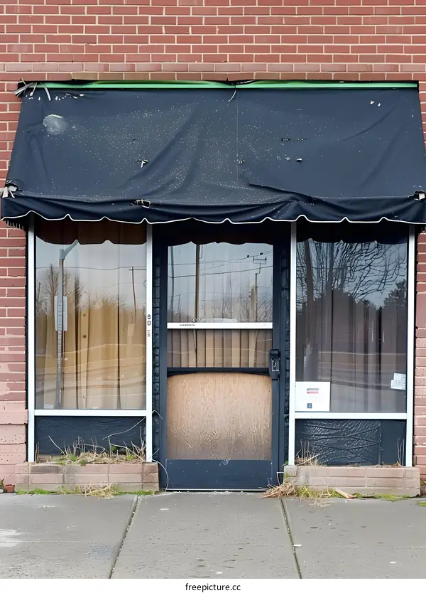 Black Awning Over A Store Front With A Brick Facade