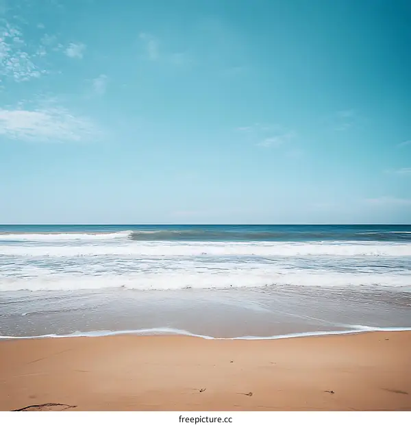 Calm Ocean Waves On Sandy Beach With Blue Sky