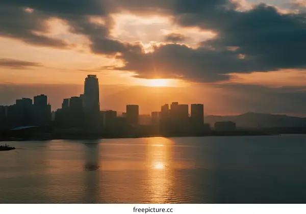 Sunset over the city skyline with water reflecting the golden light