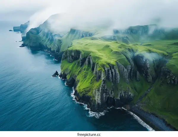 Rocky coast with green hills and a foggy sea