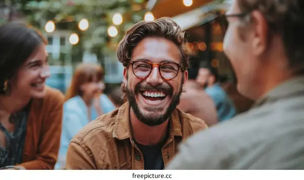 Bearded man laughing with friends in the background