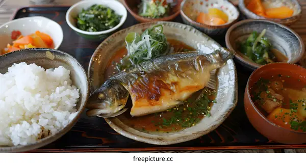 Japanese Cuisine Featuring Grilled Fish, Rice, and Side Dishes