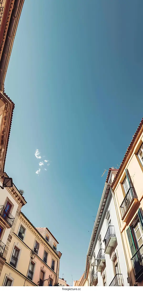 Upward View of Blue Sky and Old Buildings with Balconies in Spain