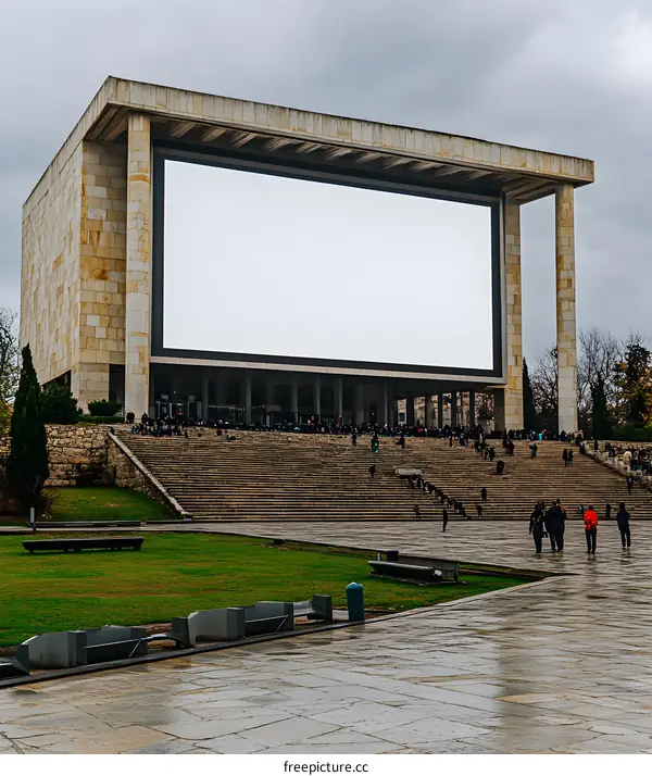 Large Blank Screen on Building Exterior with People Walking Below