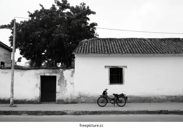 Vintage Black and White Street Scene with Old Buildings and a Motorcycle