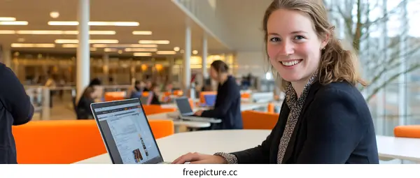 Smiling Woman Working on Laptop in Modern Office
