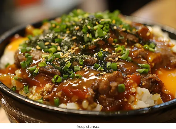 A delicious bowl of gyudon with beef, rice, and vegetables