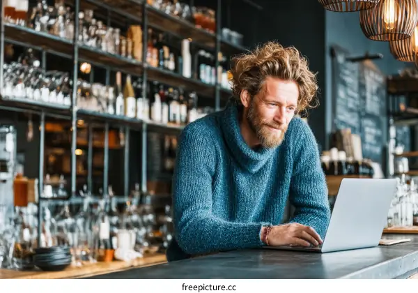 Focused Businessman Working on Laptop in Cafe