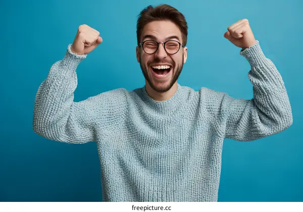 Bearded man in glasses celebrating with raised fists