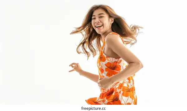 Cheerful young Asian woman in summer dress running isolated on white background
