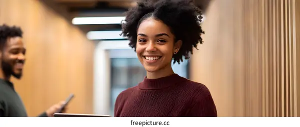 Smiling African American Woman Holding Tablet In Modern Office