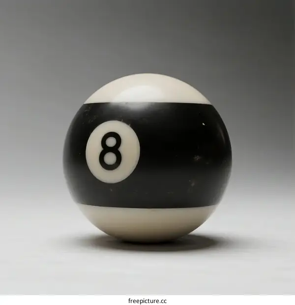 Black and white billiard ball with number eight on a plain background