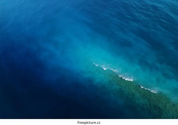 Aerial View of Turquoise Coral Reefs and Deep Blue Ocean Water