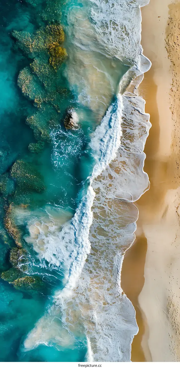 Aerial View of Ocean Waves Breaking on Sandy Beach